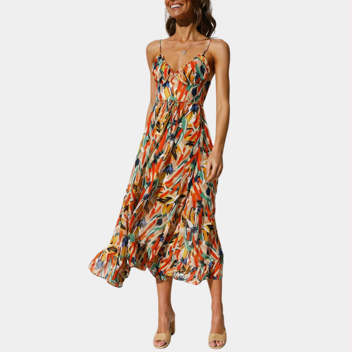 Vrouw in kleurrijke zomerjurk met abstract patroon, spaghetti bandjes en vloeiende rok. Perfect voor zomermode en casual outfits.