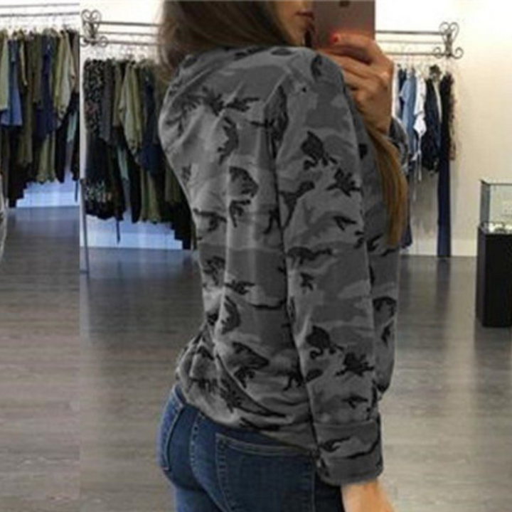 Grijze camouflage trui voor dames, gedragen in een kledingwinkel. Modieuze casual outfit, perfect voor herfst- en winterseizoenen.