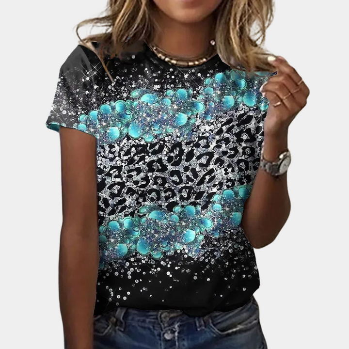 Vrouw draagt zwart T-shirt met turquoise en zilveren luipaardprint, casual stijl, modieuze dameskleding, trendy zomeroutfit, korte mouwen.