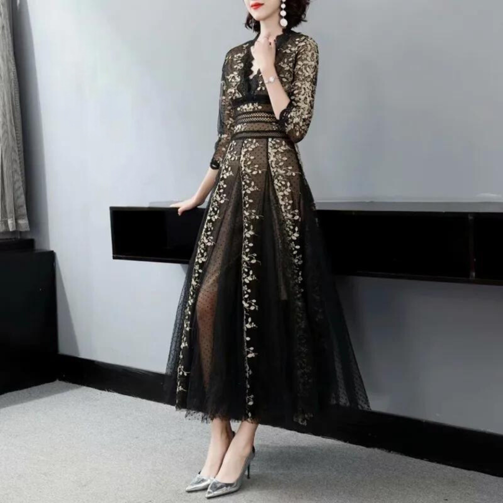 Elegante zwarte avondjurk met gouden kant, driekwart mouwen en transparante rok. Perfect voor formele gelegenheden en stijlvolle evenementen.