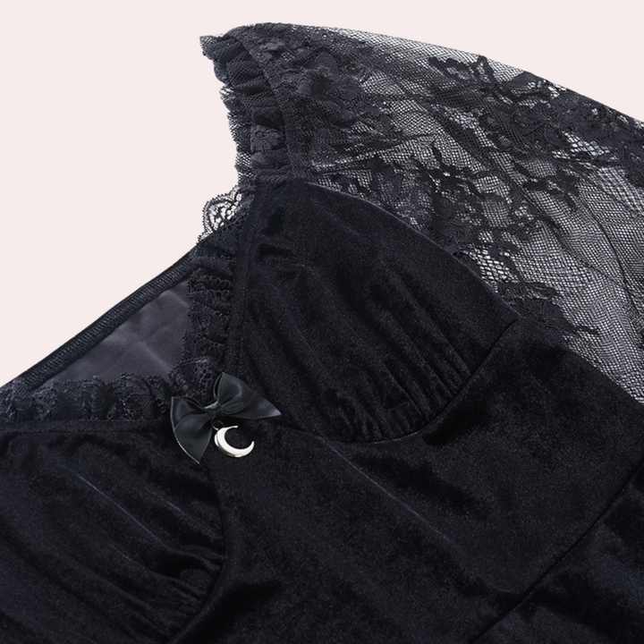 Zwarte fluwelen jurk met kanten details en strik, elegante avondkleding, stijlvolle damesmode, perfect voor formele gelegenheden.
