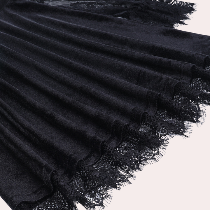 Zwarte fluwelen rok met kanten details, plooien en elegante afwerking. Perfect voor stijlvolle mode en avondkleding.