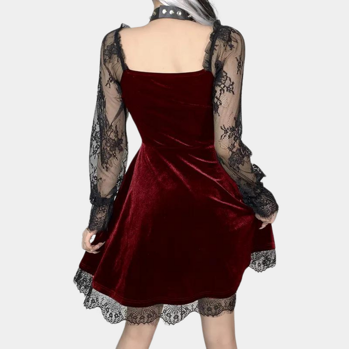 Rode fluwelen jurk met zwarte kanten mouwen, vierkante halslijn en elegante details. Perfect voor feestelijke gelegenheden en avondkleding.