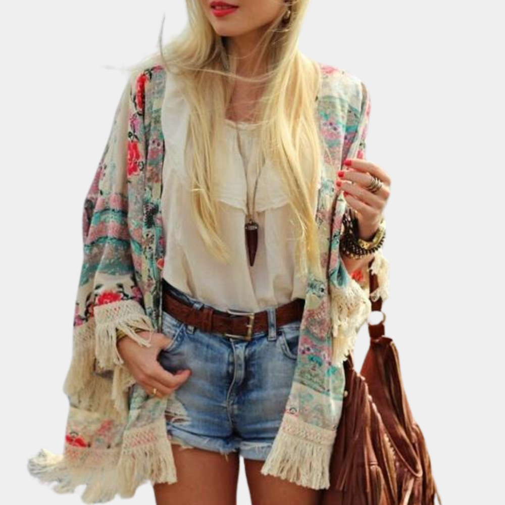 Vrouw in boho-stijl met bloemenkimono, witte blouse en denim shorts. Accessoires: bruine tas, riem en sieraden. Zomeroutfit, casual mode.