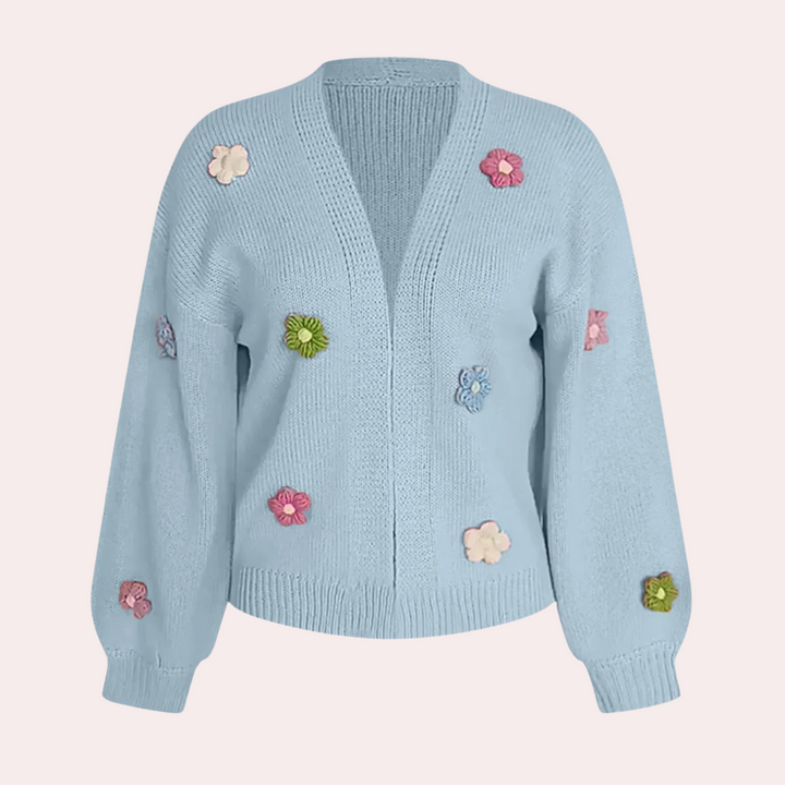 Lichtblauw gebreid damesvest met kleurrijke bloemenapplicaties, lange mouwen en open voorkant. Trendy en stijlvol voor casual outfits.