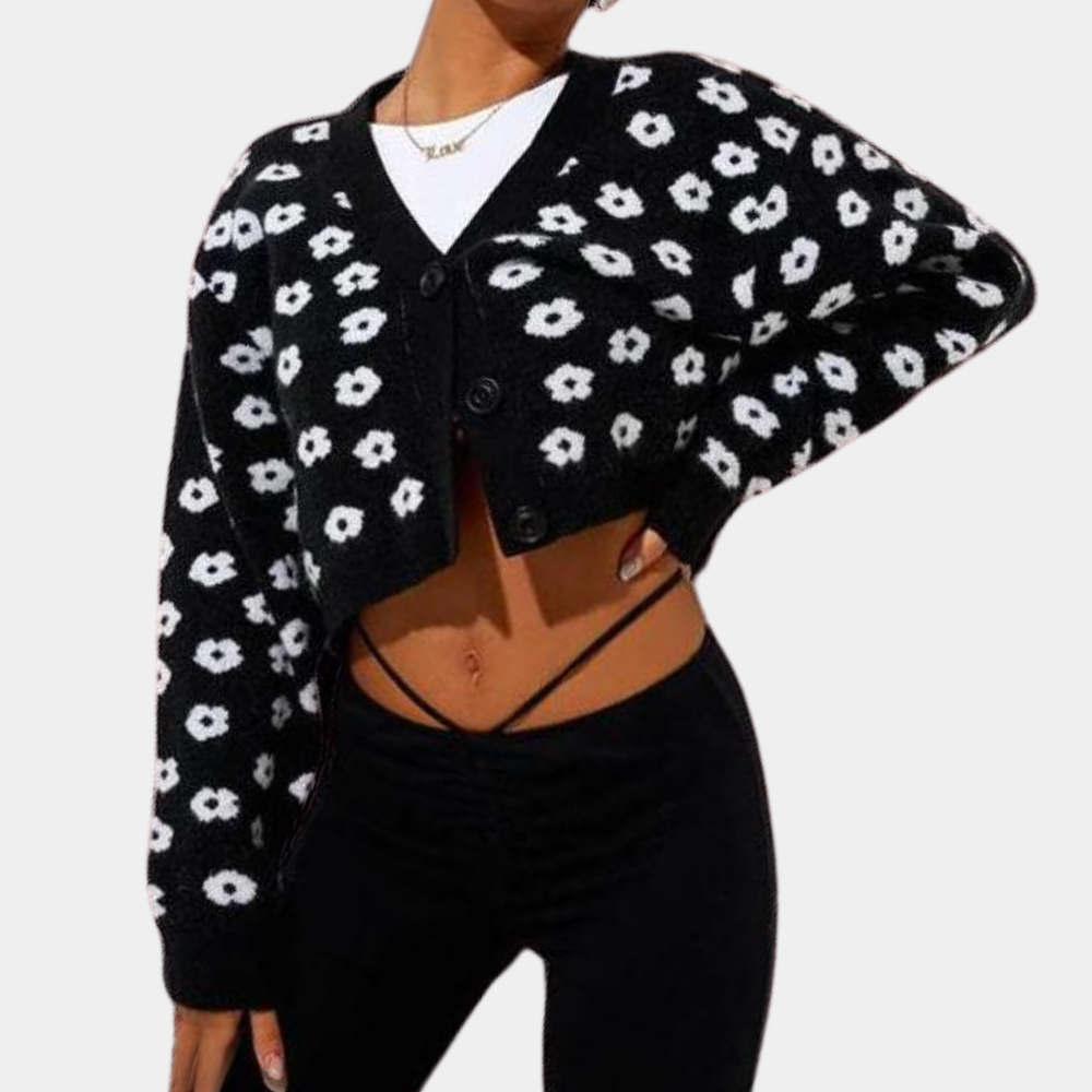 Zwarte cropped cardigan met witte bloemenprint, lange mouwen en knoopsluiting. Trendy damesmode, ideaal voor casual en stijlvolle outfits.