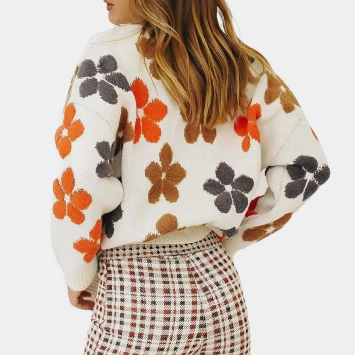 Vrouw draagt witte trui met kleurrijke bloemenprint en geruite broek. Modieuze dameskleding, herfststijl, trendy outfit, casual chic.