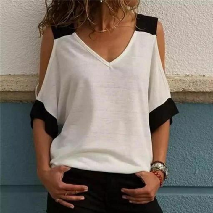Vrouw draagt witte off-shoulder top met zwarte accenten, casual mode, trendy dameskleding, zomeroutfit, stijlvolle blouse, modieuze look.