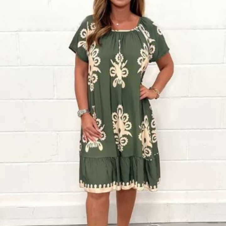 Groene damesjurk met witte bloemenprint, korte mouwen en ronde hals. Perfect voor casual zomeroutfits. Comfortabele en stijlvolle mode.