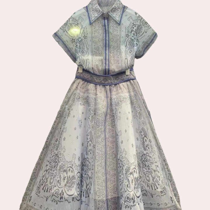 Blauwe damesjurk met korte mouwen en kraag, versierd met paisley-patroon. Elegante zomerjurk, perfect voor casual en formele gelegenheden.