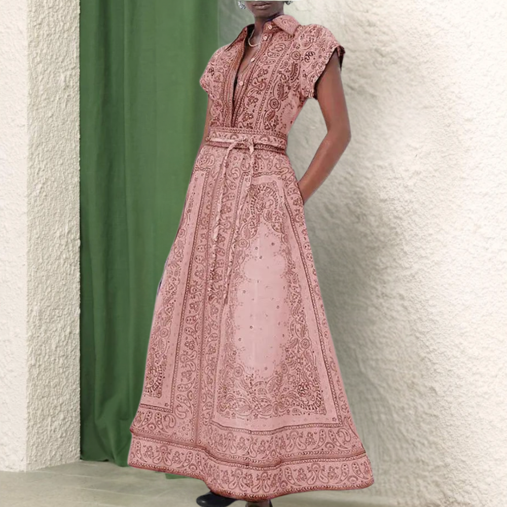 Roze maxi-jurk met korte mouwen en gedetailleerd paisley-patroon, perfect voor zomerse evenementen. Elegante damesmode, bohemian stijl.