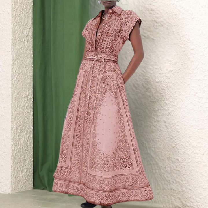 Roze maxi-jurk met korte mouwen en gedetailleerd paisley-patroon, perfect voor zomerse evenementen. Elegante damesmode, bohemian stijl.