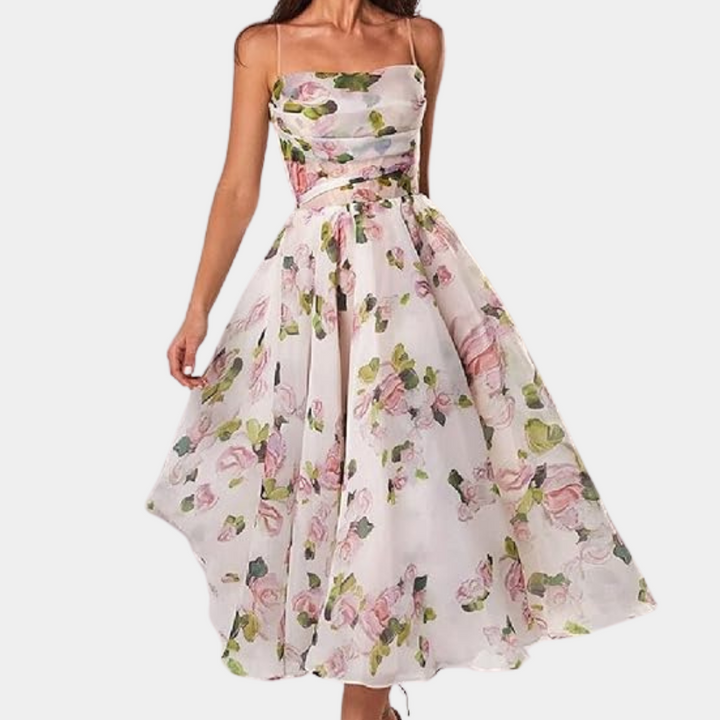 Vrouw in elegante, strapless witte bloemenjurk met roze en groene accenten, perfecte zomerjurk voor bruiloften of tuinfeesten.