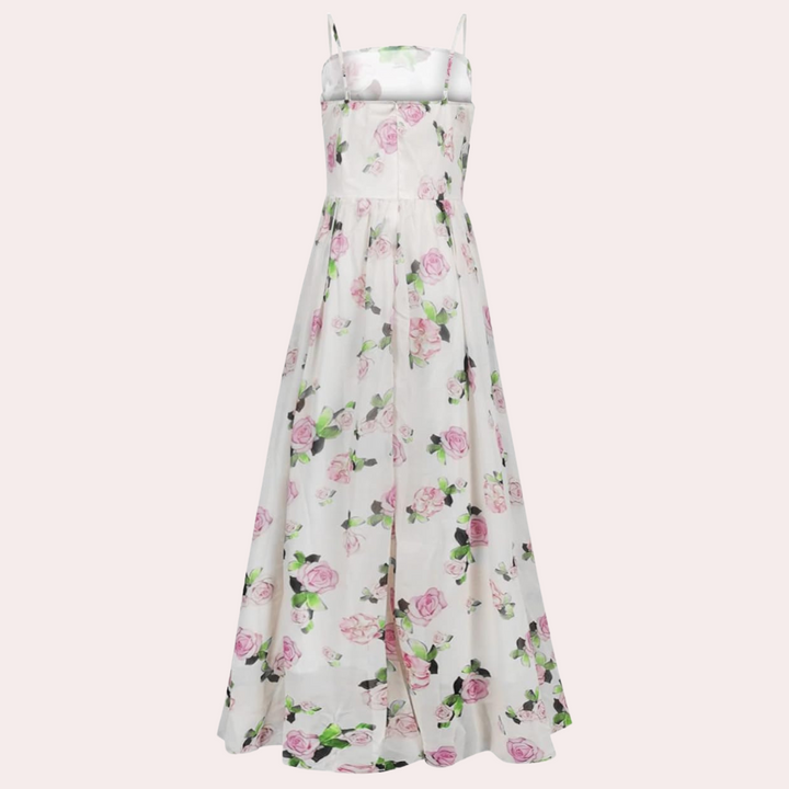 Witte maxi-jurk met roze bloemenprint, spaghetti bandjes en vloeiende rok. Perfect voor zomerse evenementen en bruiloften. Elegante damesmode.