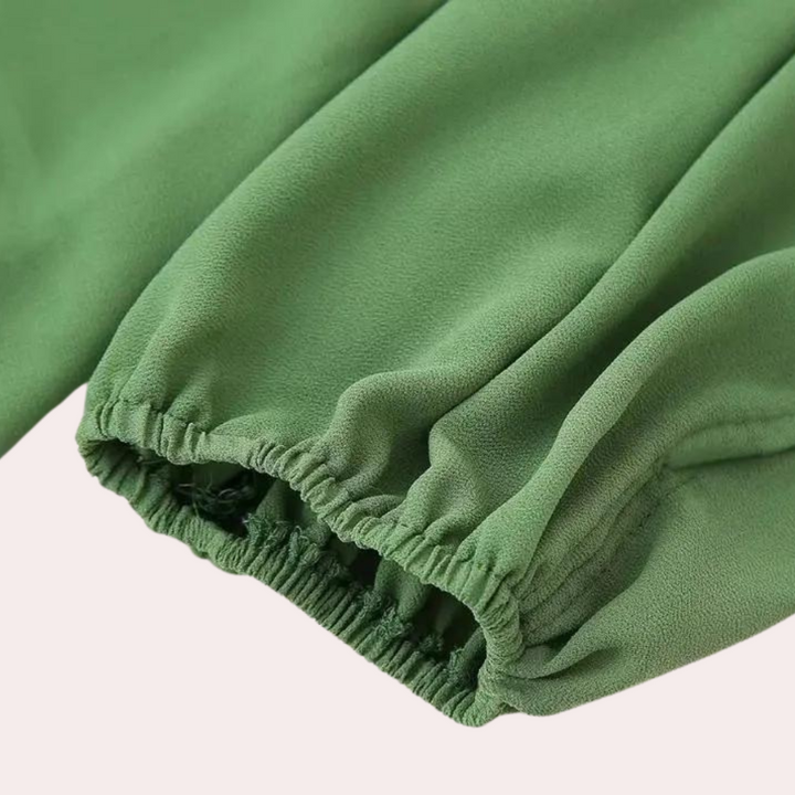 Groene blouse met elastische mouwboord, gemaakt van zachte stof. Ideaal voor damesmode, casual en formele outfits. Trendy en comfortabel.