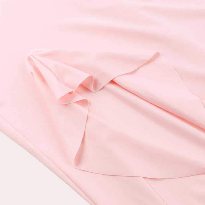 Lichtroze zijden stof met elegante plooien, ideaal voor modeontwerp en kledingproductie. Hoogwaardige textielmaterialen, zacht en luxueus.