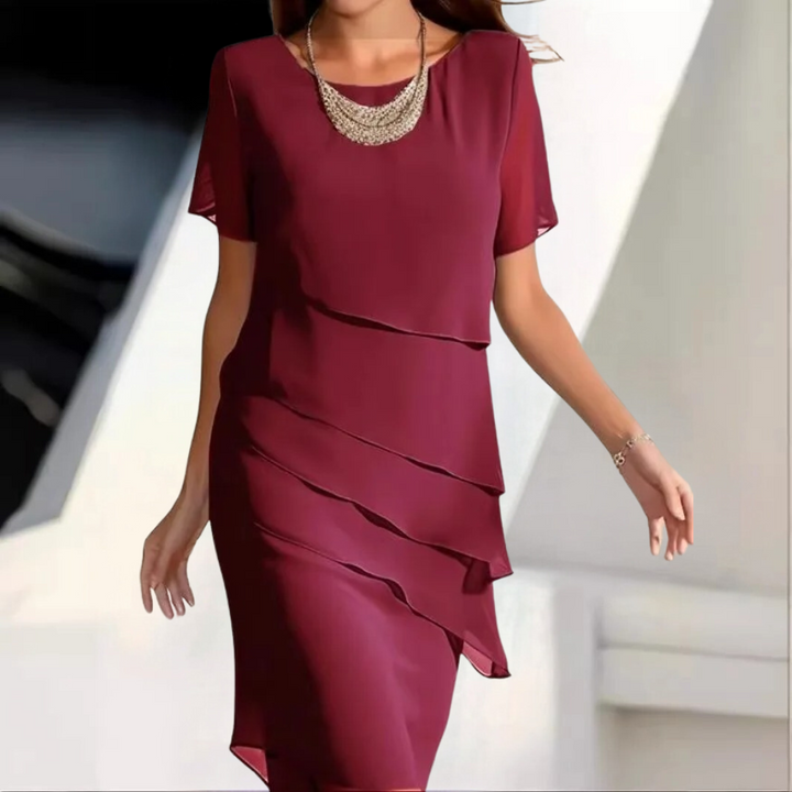 Rode avondjurk met gelaagde chiffon lagen en elegante halsketting, perfect voor formele gelegenheden. Stijlvolle damesmode, chique avondkleding.