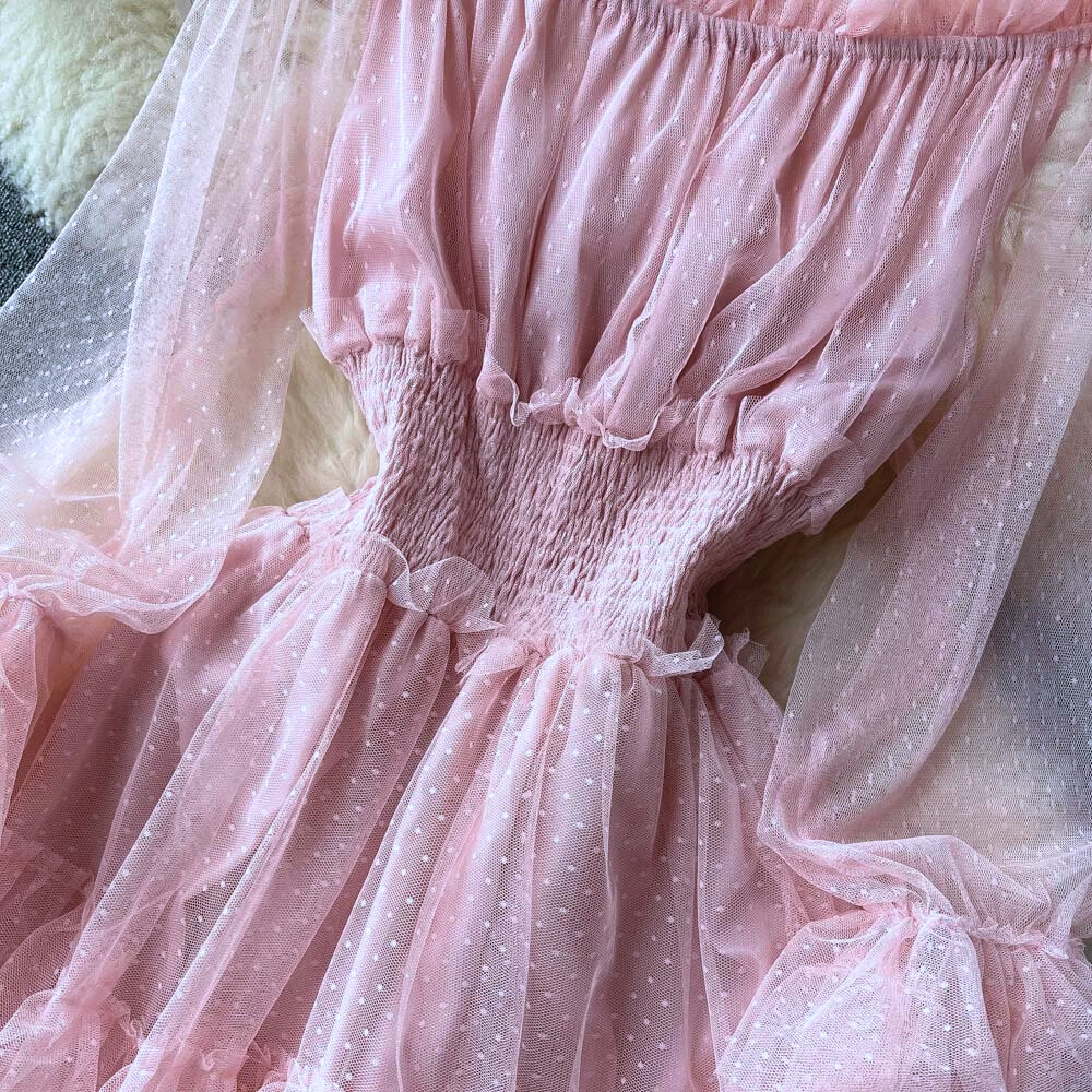 Roze doorschijnende jurk met stippenpatroon, ruches en elastische taille, elegant en modieus ontwerp voor speciale gelegenheden.