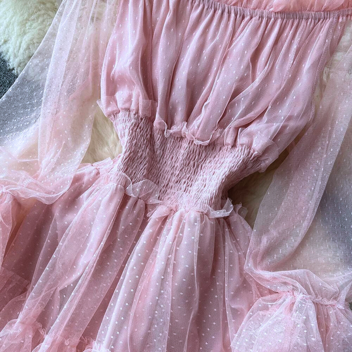 Roze doorschijnende jurk met stippenpatroon, ruches en elastische taille, elegant en modieus ontwerp voor speciale gelegenheden.