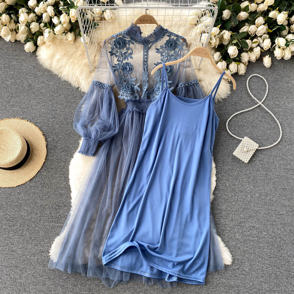 Blauwe kanten jurk met lange mouwen en bloemenpatroon, naast een effen blauwe slipdress. Perfect voor elegante gelegenheden en zomerfeesten.