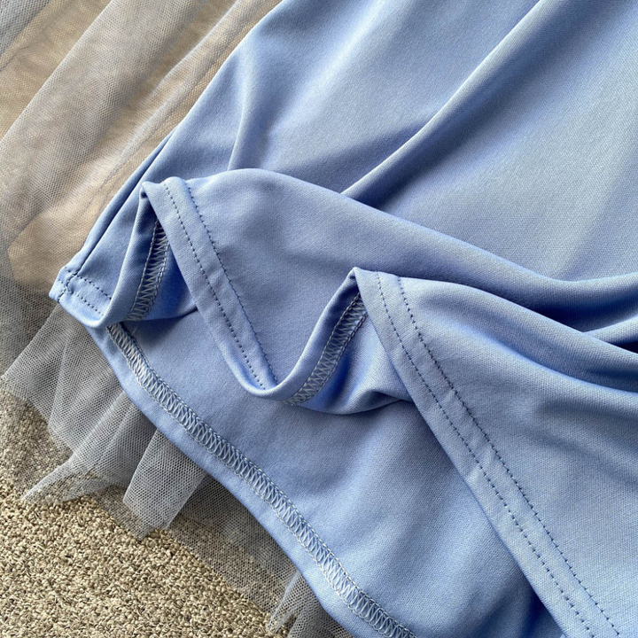 Blauwe jurkstof met tule details, close-up. Zachte, vloeiende textuur, perfect voor elegante avondjurken. Hoogwaardige mode- en stoffenmaterialen.