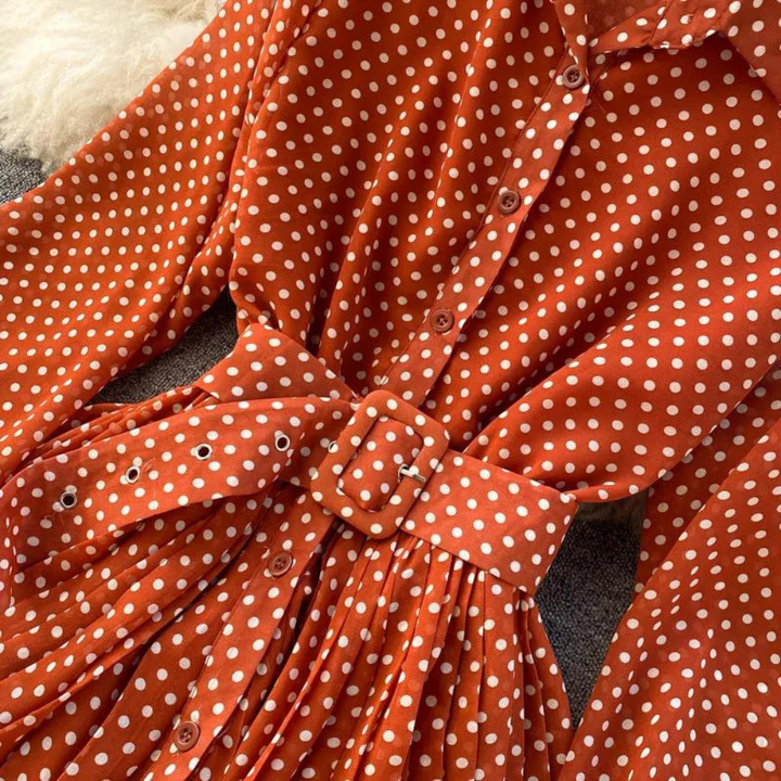 Oranje-rode jurk met witte stippen, knoopsluiting en ceintuur. Trendy damesmode, polkadot patroon, elegante vintage stijl. Perfect voor casual outfits.