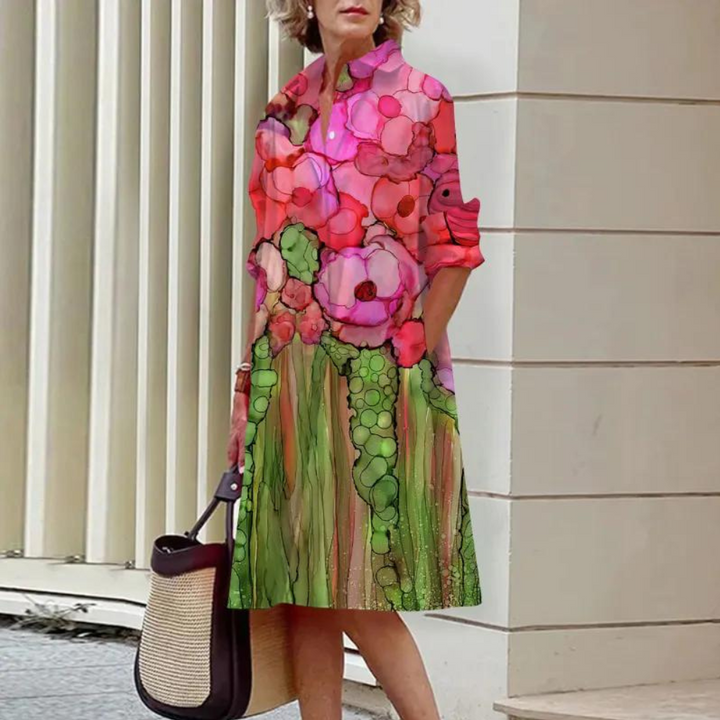 Vrouw in kleurrijke bloemenjurk met abstracte print, staand bij moderne architectuur. Mode, dameskleding, zomerjurk, casual stijl.
