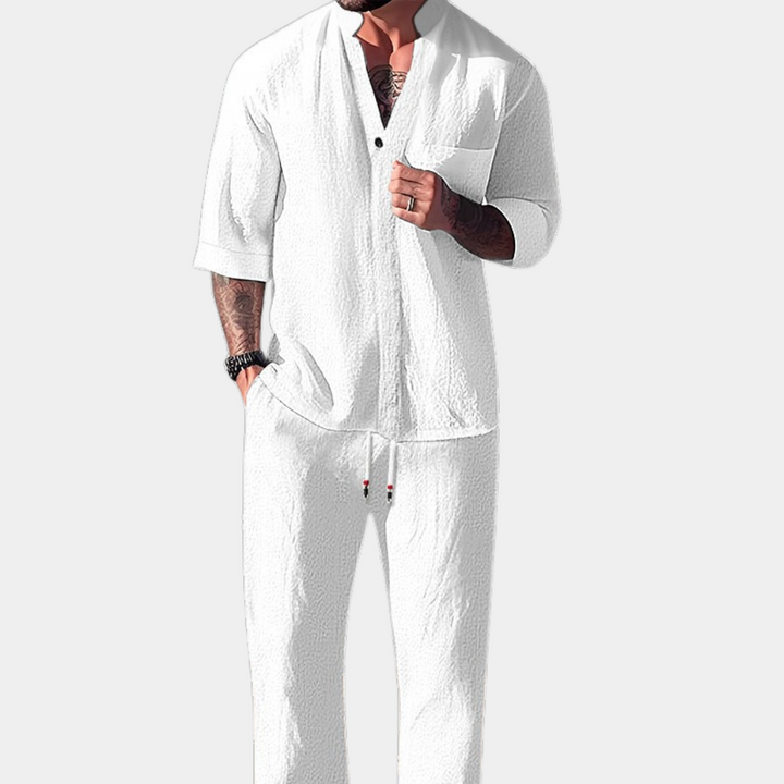 Witte herenlinnen outfit, bestaande uit een casual overhemd met opgerolde mouwen en een comfortabele broek. Perfect voor zomerse gelegenheden.