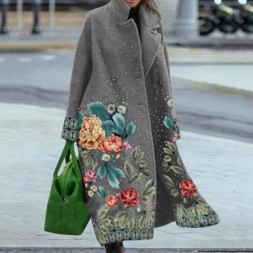 Grijze damesjas met kleurrijke bloemenprint, lange mouwen en groene handtas. Stijlvolle wintermode, elegant design, warme kleding.