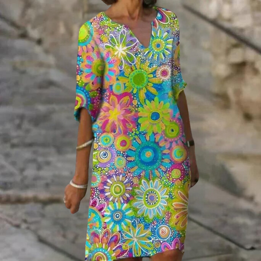 Vrouw in kleurrijke bloemenjurk met korte mouwen, levendig patroon, zomermode, casual stijl, perfect voor strand- of stadsuitjes.
