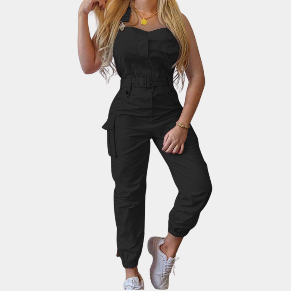 Vrouw in zwarte jumpsuit met riem, cargo zakken en witte sneakers. Modieuze dameskleding, casual stijl, trendy outfit voor dagelijks gebruik.