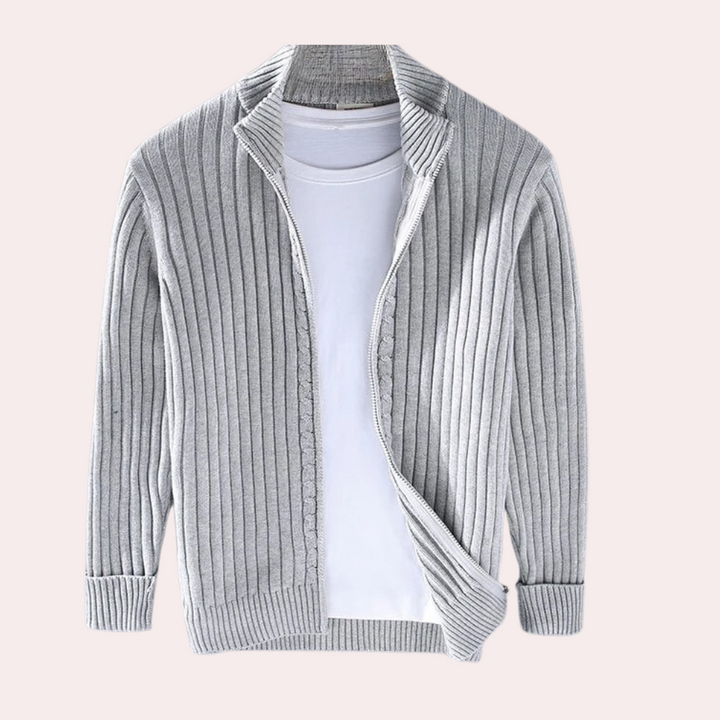 Lichtgrijs geribbelde heren cardigan met open voorkant, gecombineerd met een witte T-shirt. Stijlvolle casual herenkleding, perfect voor herfst.
