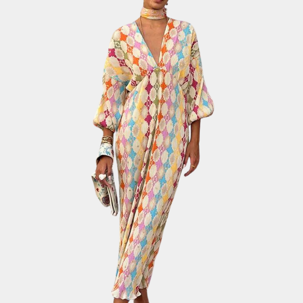 Vrouw in kleurrijke, lange boho-jurk met ruitpatroon en wijde mouwen, draagt bijpassende accessoires. Perfect voor zomerse mode en bohemian stijl.