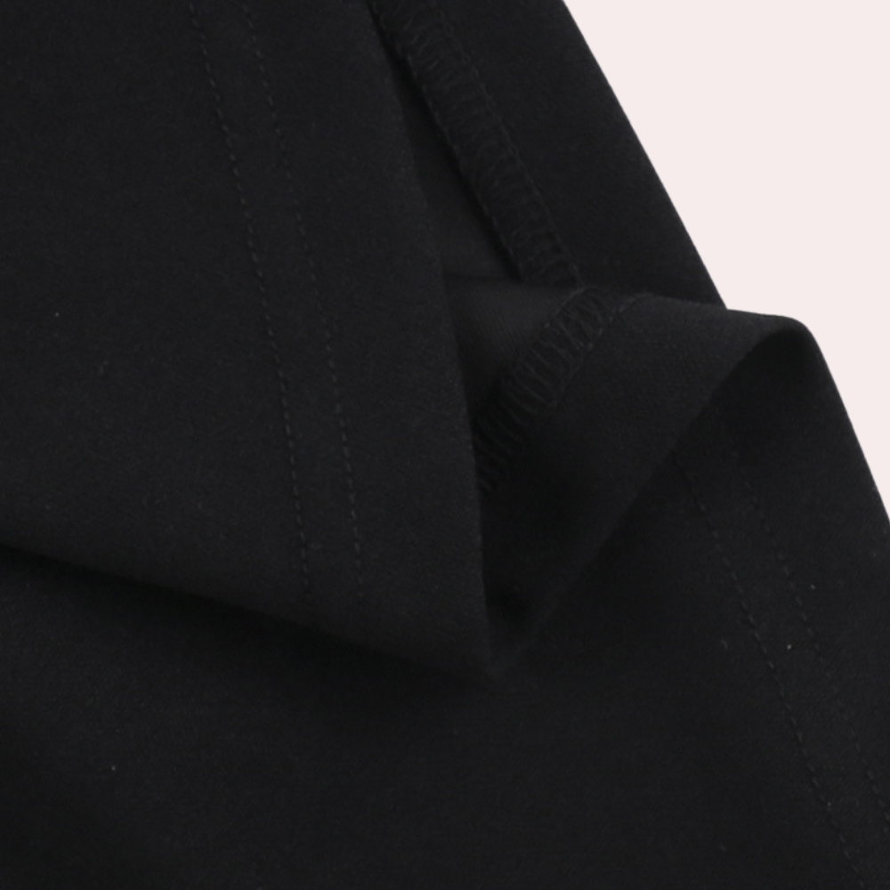 Zwarte katoenen stof close-up, naad en textuur zichtbaar. Ideaal voor kleding, modeontwerp, hoogwaardige textielmaterialen.