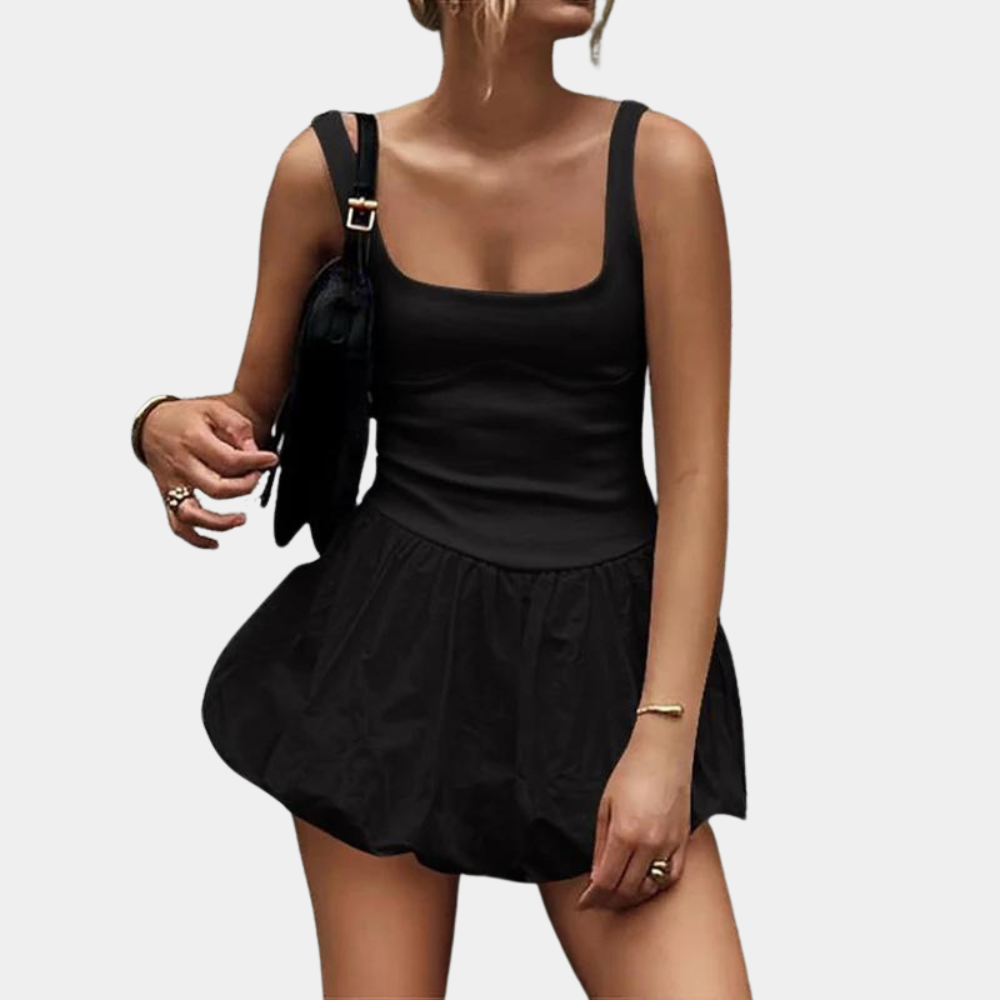 Vrouw in zwarte, mouwloze jurk met vierkante halslijn en geplooide rok, draagt zwarte schoudertas. Trendy damesmode, casual zomeroutfit.