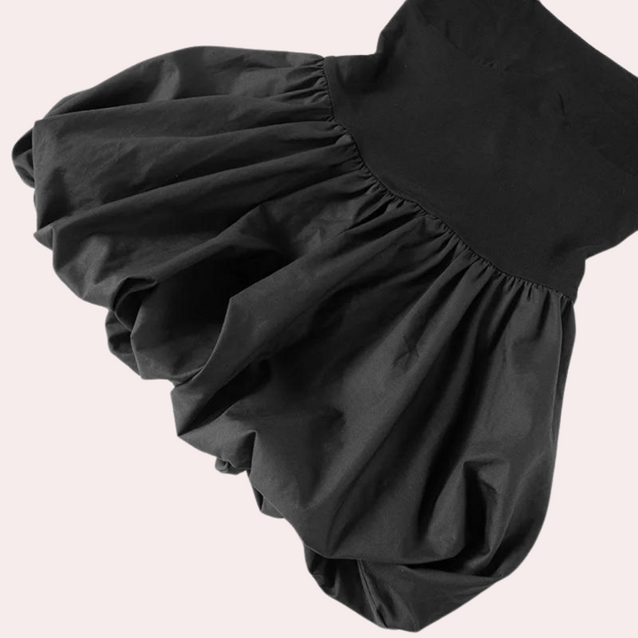 Zwarte ballonrok met hoge taille, elegante plooien en volumineuze stijl. Perfect voor modieuze outfits en veelzijdige combinaties.