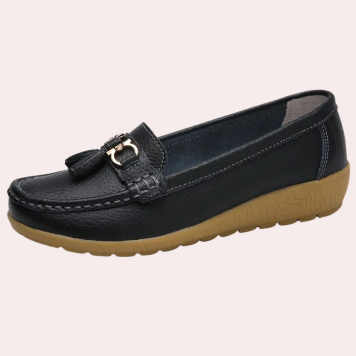 Zwarte leren mocassin met kwastje en gesp, comfortabele bruine rubberen zool, dames instapper, stijlvol en duurzaam schoeisel voor dagelijks gebruik.
