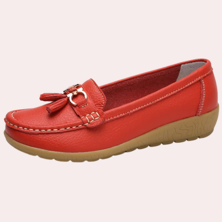 Rode leren mocassin voor dames met decoratieve kwastjes en comfortabele rubberen zool. Stijlvolle en duurzame schoenen voor dagelijks gebruik.