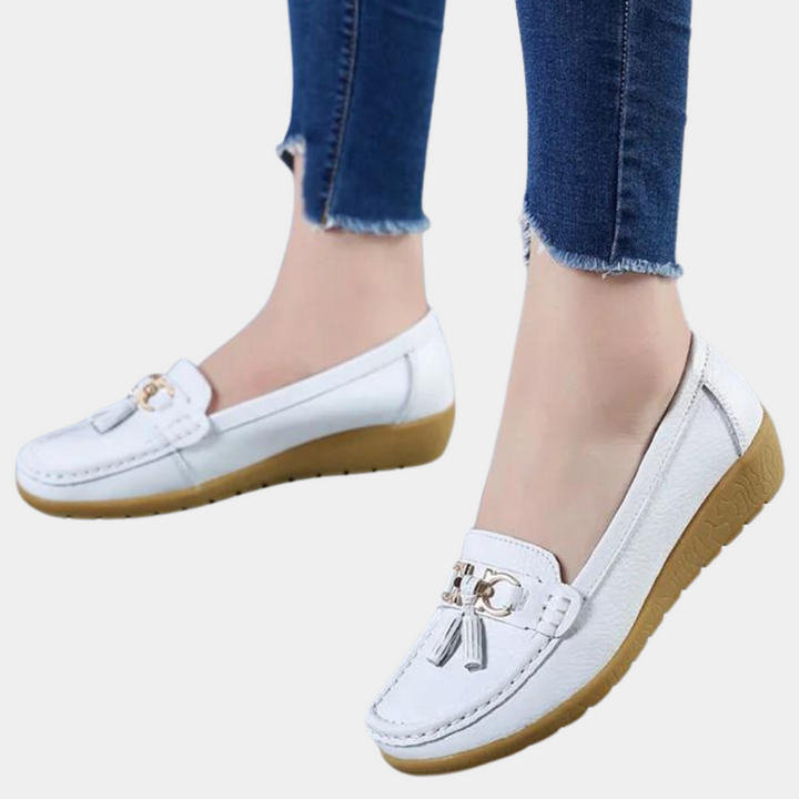 Witte leren loafers met gouden details en kwastjes, gedragen met blauwe jeans. Comfortabele dames schoenen, casual stijl, perfecte pasvorm.