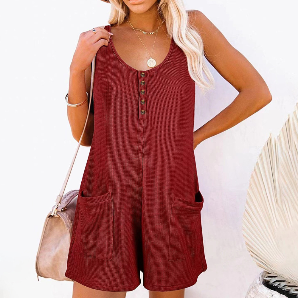 Vrouw in wijnrode zomerjurk met knoopsluiting en zakken, strandtas over schouder. Perfect voor zomermode en casual strandoutfits.