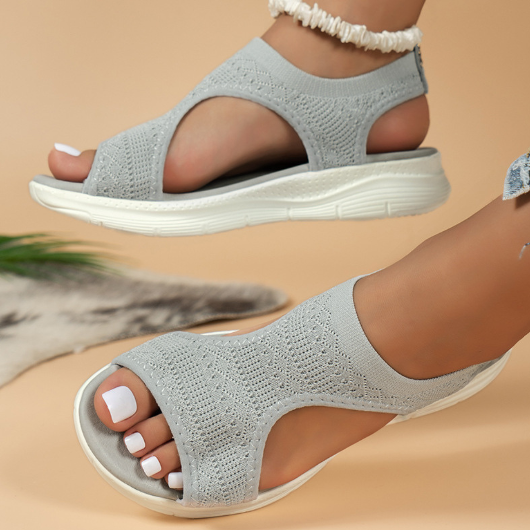 Grijze dames sandalen met open teen en gebreid bovenwerk, comfortabele witte zool. Perfect voor zomerse outfits en casual stijl.