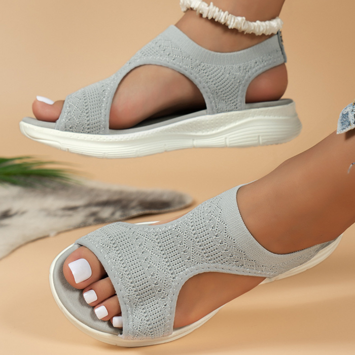 Grijze dames sandalen met open teen en gebreid bovenwerk, comfortabele witte zool. Perfect voor zomerse outfits en casual stijl.