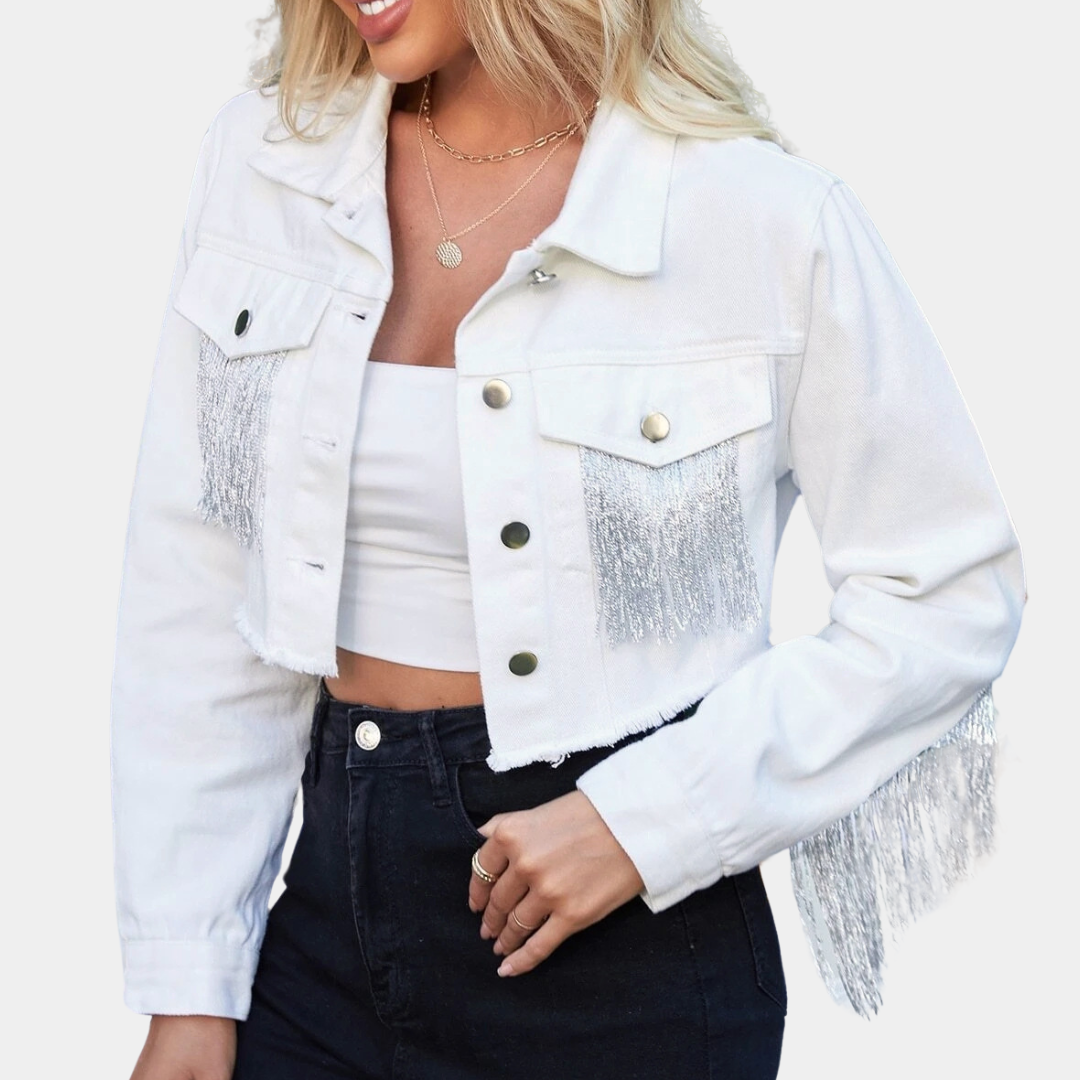 Vrouw in witte cropped spijkerjas met franjes, gouden knopen en zwarte jeans. Modieuze dameskleding, trendy streetwear, casual outfit.