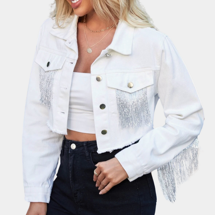 Vrouw in witte cropped spijkerjas met franjes, gouden knopen en zwarte jeans. Modieuze dameskleding, trendy streetwear, casual outfit.