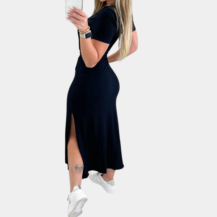 Vrouw in zwarte midi-jurk met split, witte sneakers en smartwatch, maakt selfie. Modieuze dameskleding, casual stijl, zomeroutfit.