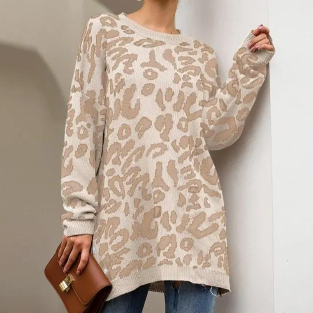 Vrouw draagt beige oversized trui met luipaardprint, gecombineerd met blauwe jeans en bruine clutch. Modieuze dameskleding, herfststijl.