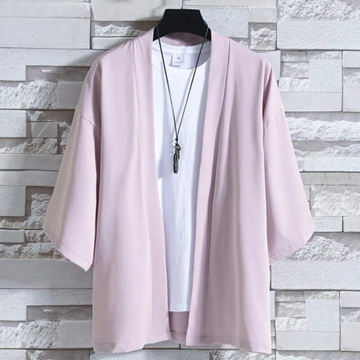 Roze kimono jasje op hanger, voor witte bakstenen muur. Modieuze dameskleding, casual stijl, ideaal voor lente en zomer.