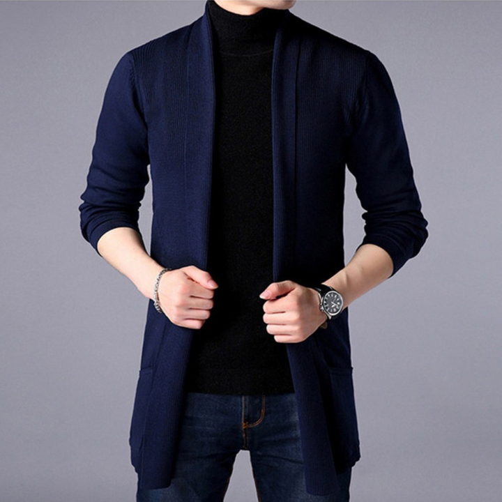 Donkerblauwe heren cardigan, open stijl, gedragen over zwarte coltrui en jeans. Modieuze herenkleding, casual en stijlvol.