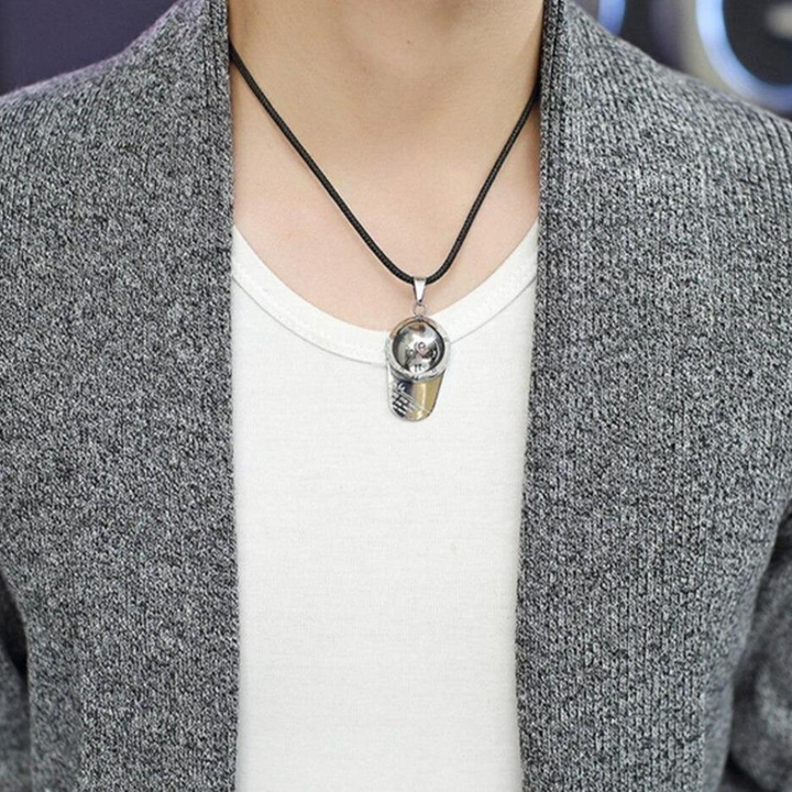 Grijze trui met witte top en zilveren ketting met hanger. Stijlvolle herenmode, casual outfit, moderne accessoires, trendy look.