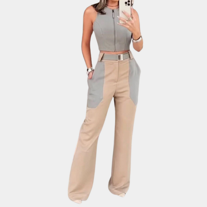 Vrouw in stijlvolle tweekleurige jumpsuit met grijze top en beige broek, modieuze outfit, trendy dameskleding, moderne mode.